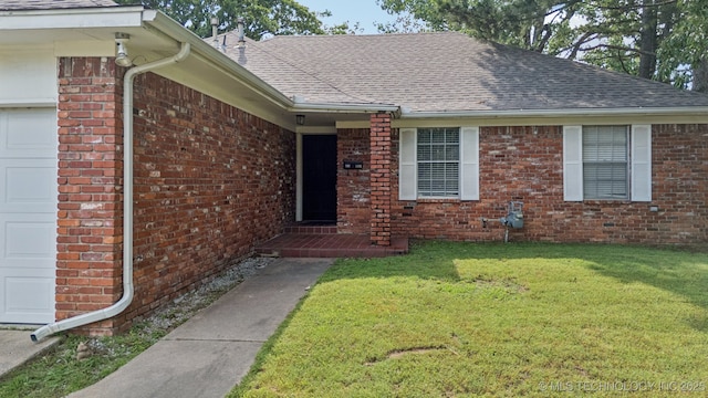 1110 S Division St, Sapulpa, OK 74066 - view of exterior entry featuring a garage, brick siding, a shingled roof, and a lawn