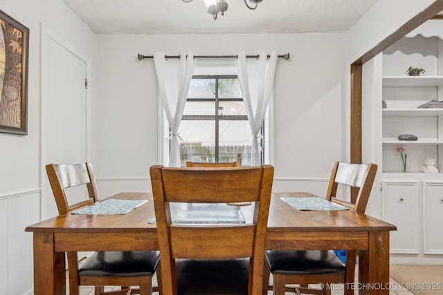 1110 S Division St, Sapulpa, OK 74066 - dining space with a textured ceiling, a chandelier, and wainscoting