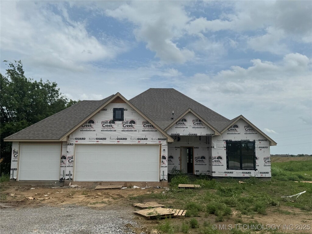 14045 N 54th E Ave, Collinsville, OK 74021 - unfinished property featuring an attached garage, a shingled roof, and driveway