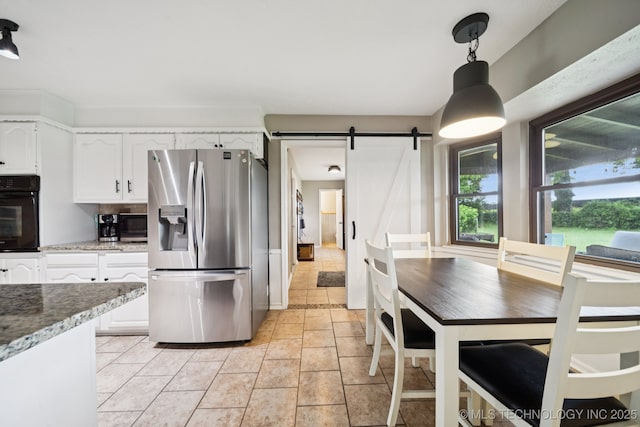 12350 E 138th St S, Broken Arrow, OK 74011 - kitchen with stainless steel appliances, a barn door, white cabinetry, hanging light fixtures, and light stone counters