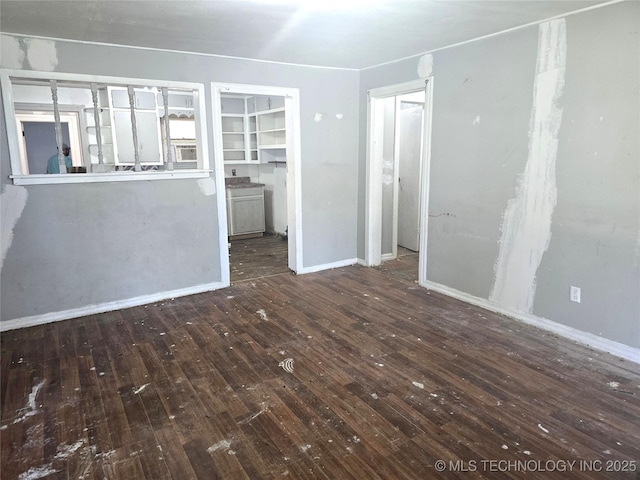 701 4th Ave SE, Ardmore, OK 73401 - unfurnished living room with hardwood / wood-style floors and baseboards