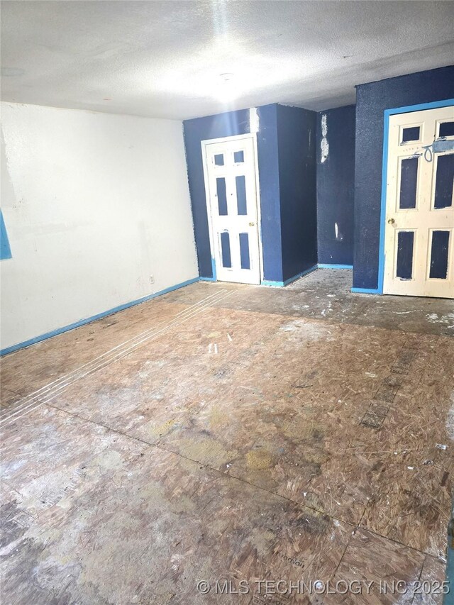 701 4th Ave SE, Ardmore, OK 73401 - spare room with a textured ceiling and baseboards