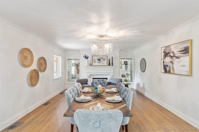 302 E 29th St, Tulsa, OK 74114 - dining area with a chandelier, baseboards, ornamental molding, light wood finished floors, and a glass covered fireplace