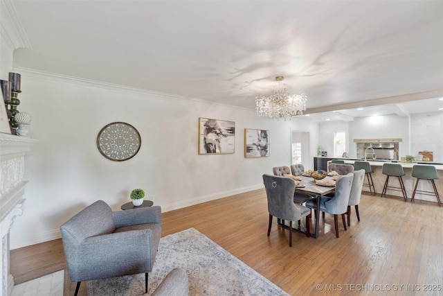 302 E 29th St, Tulsa, OK 74114 - dining area with a fireplace, a chandelier, baseboards, light wood-style floors, and ornamental molding