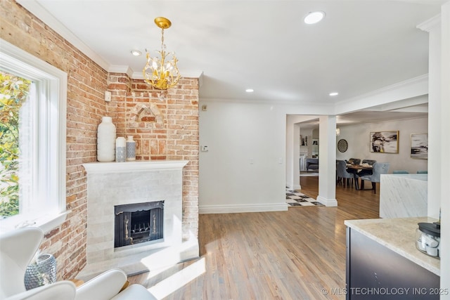 302 E 29th St, Tulsa, OK 74114 - living room with crown molding, a brick fireplace, baseboards, wood finished floors, and recessed lighting