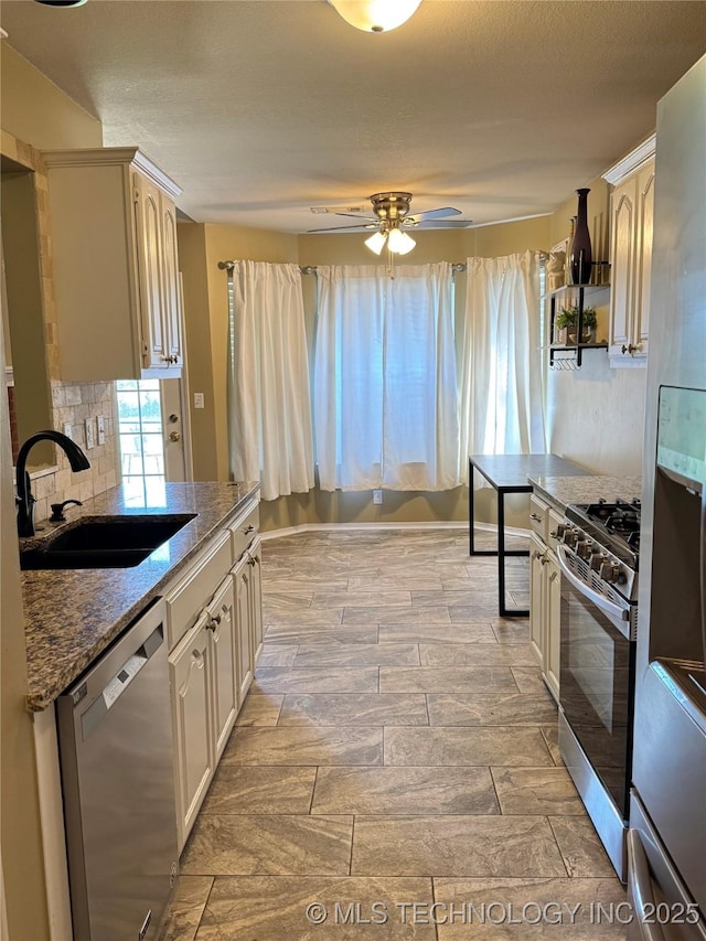 509 W Ryan St, Catoosa, OK 74015 - kitchen featuring appliances with stainless steel finishes, a sink, a ceiling fan, dark stone countertops, and tasteful backsplash