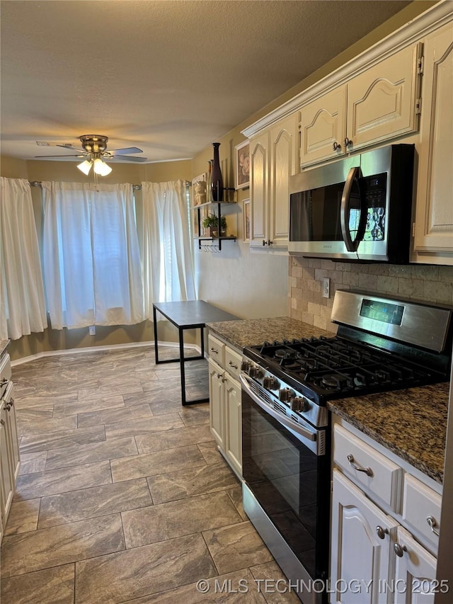 509 W Ryan St, Catoosa, OK 74015 - kitchen featuring appliances with stainless steel finishes, decorative backsplash, ceiling fan, and dark stone counters