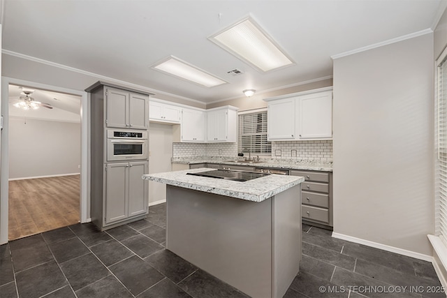 4908 S Redbud Ave, Broken Arrow, OK 74011 - kitchen with black electric stovetop, light countertops, tasteful backsplash, oven, and a kitchen island