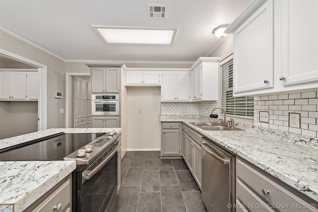 4908 S Redbud Ave, Broken Arrow, OK 74011 - kitchen featuring stainless steel appliances, a sink, tasteful backsplash, light stone counters, and ornamental molding
