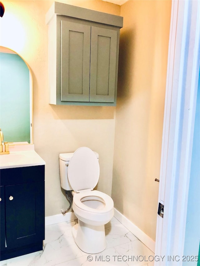 1423 E Walnut St, Cushing, OK 74023 - bathroom with marble finish floors, vanity, toilet, and baseboards