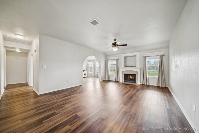 109 W 133rd Pl, Skiatook, OK 74070 - unfurnished living room with a ceiling fan, dark wood-style floors, arched walkways, baseboards, and a fireplace