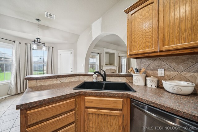 109 W 133rd Pl, Skiatook, OK 74070 - kitchen featuring stainless steel dishwasher, a sink, decorative backsplash, arched walkways, and healthy amount of natural light