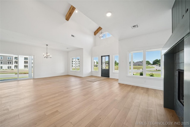 2410 W Charleston St, Broken Arrow, OK 74011 - unfurnished living room featuring a chandelier, a fireplace, beamed ceiling, baseboards, and light wood-style floors