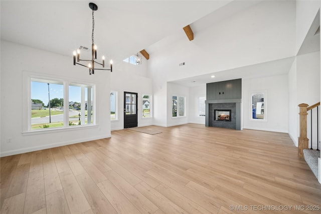 2410 W Charleston St, Broken Arrow, OK 74011 - unfurnished living room featuring a chandelier, light wood finished floors, beamed ceiling, baseboards, and a multi sided fireplace