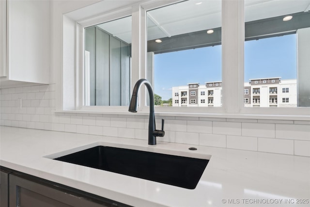 2410 W Charleston St, Broken Arrow, OK 74011 - kitchen view of a sink, light countertops, decorative backsplash, white cabinetry, and recessed lighting