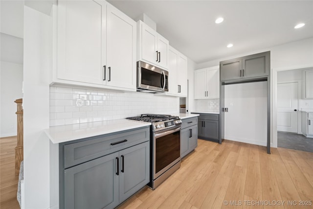 2410 W Charleston St, Broken Arrow, OK 74011 - kitchen with stainless steel appliances, gray cabinets, light countertops, light wood-type flooring, and recessed lighting