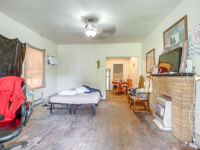 309 W 14th, Ada, OK 74820 - bedroom with wood finished floors, heating unit, a fireplace, and ceiling fan