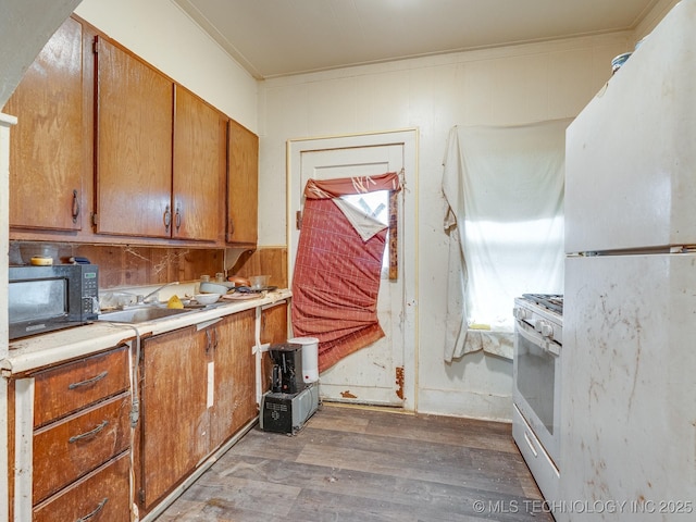 309 W 14th, Ada, OK 74820 - kitchen featuring white appliances, light wood-type flooring, crown molding, light countertops, and brown cabinetry