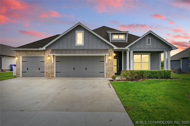 31594 E 64th St S, Broken Arrow, OK 74014 - view of front facade featuring board and batten siding, a garage, a lawn, driveway, and a shingled roof