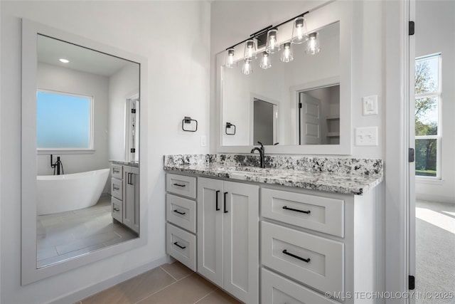 2332 E 135th Dr S, Bixby, OK 74008 - bathroom with vanity, a freestanding tub, plenty of natural light, and tile patterned floors
