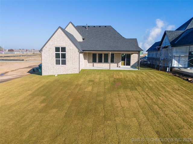 2332 E 135th Dr S, Bixby, OK 74008 - back of property with brick siding, a yard, a patio, and board and batten siding