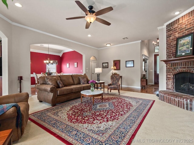 5816 Woodland Rd, Bartlesville, OK 74006 - living area featuring arched walkways, crown molding, a fireplace, recessed lighting, and carpet flooring