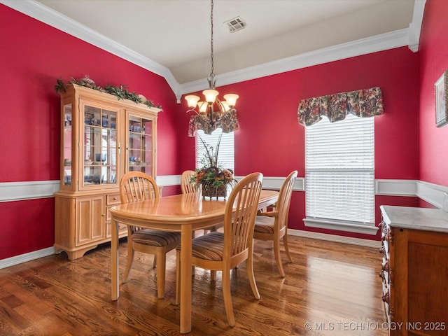 5816 Woodland Rd, Bartlesville, OK 74006 - dining room featuring ornamental molding, a chandelier, and dark wood finished floors