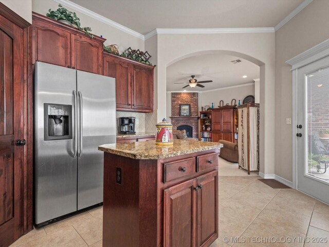5816 Woodland Rd, Bartlesville, OK 74006 - kitchen with stainless steel fridge with ice dispenser, light tile patterned floors, ceiling fan, crown molding, and a center island