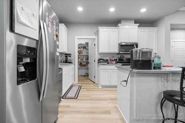 40 Wilson Pkwy, Durant, OK 74701 - kitchen with appliances with stainless steel finishes, light wood finished floors, white cabinets, recessed lighting, and tasteful backsplash