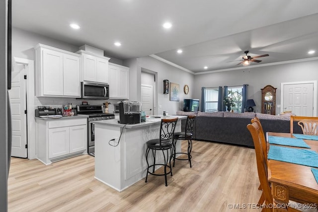40 Wilson Pkwy, Durant, OK 74701 - kitchen featuring appliances with stainless steel finishes, open floor plan, a ceiling fan, ornamental molding, and a center island