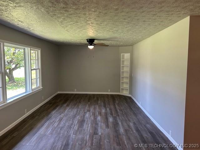 111 E 13th Pl, Claremore, OK 74017 - empty room with a textured ceiling, dark wood-type flooring, a ceiling fan, and baseboards