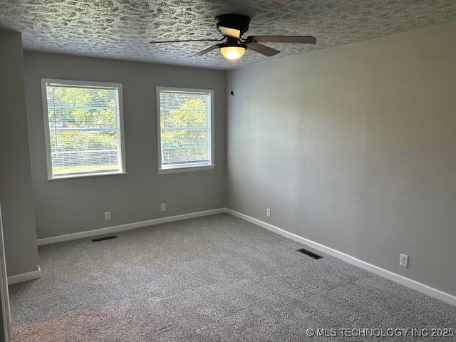 111 E 13th Pl, Claremore, OK 74017 - carpeted empty room featuring baseboards, a ceiling fan, and a textured ceiling
