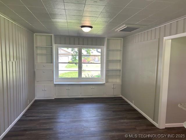 111 E 13th Pl, Claremore, OK 74017 - empty room featuring dark wood-style floors and baseboards