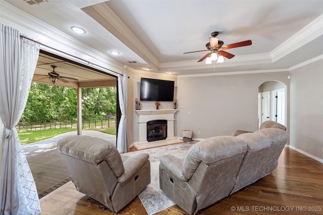 18932 Spring Creek Ln, Claremore, OK 74017 - living area featuring ceiling fan, a raised ceiling, arched walkways, ornamental molding, and recessed lighting