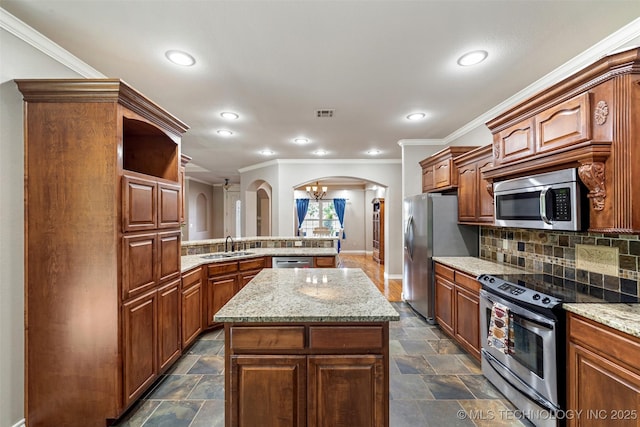 18932 Spring Creek Ln, Claremore, OK 74017 - kitchen with stainless steel appliances, arched walkways, a peninsula, a sink, and baseboards