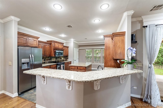 18932 Spring Creek Ln, Claremore, OK 74017 - kitchen with stainless steel appliances, dark wood-style floors, a breakfast bar, tasteful backsplash, and crown molding