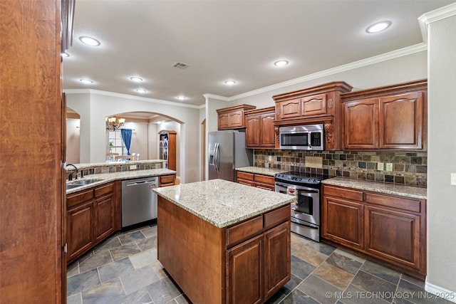 18932 Spring Creek Ln, Claremore, OK 74017 - kitchen with appliances with stainless steel finishes, arched walkways, a center island, tasteful backsplash, and recessed lighting