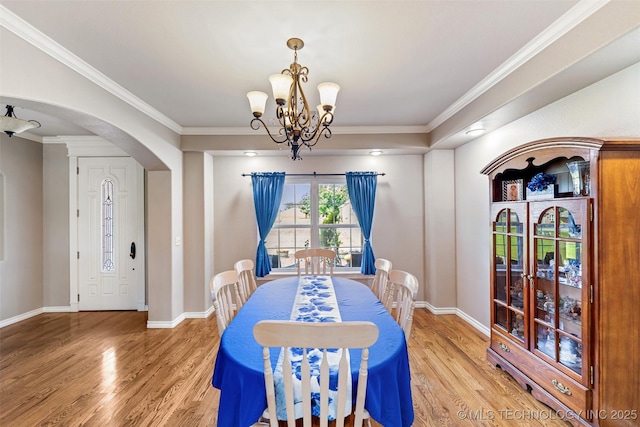 18932 Spring Creek Ln, Claremore, OK 74017 - dining area featuring arched walkways, a chandelier, light wood finished floors, baseboards, and ornamental molding