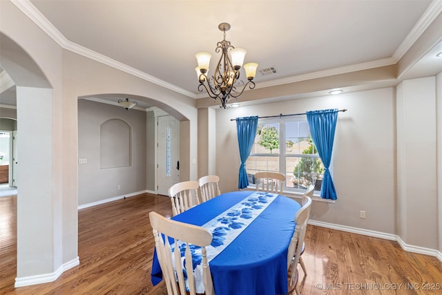 18932 Spring Creek Ln, Claremore, OK 74017 - dining area featuring arched walkways, a chandelier, wood finished floors, baseboards, and ornamental molding
