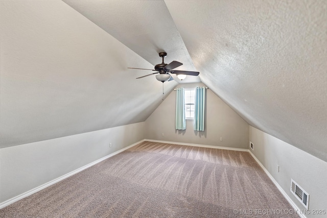 18932 Spring Creek Ln, Claremore, OK 74017 - bonus room featuring a textured ceiling, vaulted ceiling, light colored carpet, baseboards, and ceiling fan