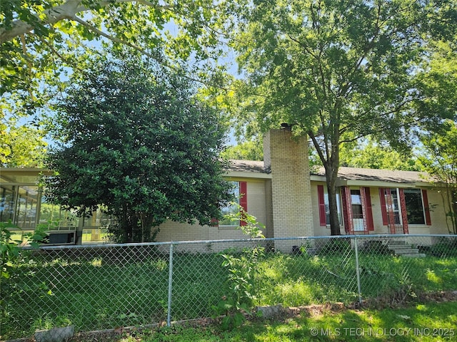 2700 N Witte St, Poteau, OK 74953 - view of front of property featuring a chimney, brick siding, and a fenced front yard