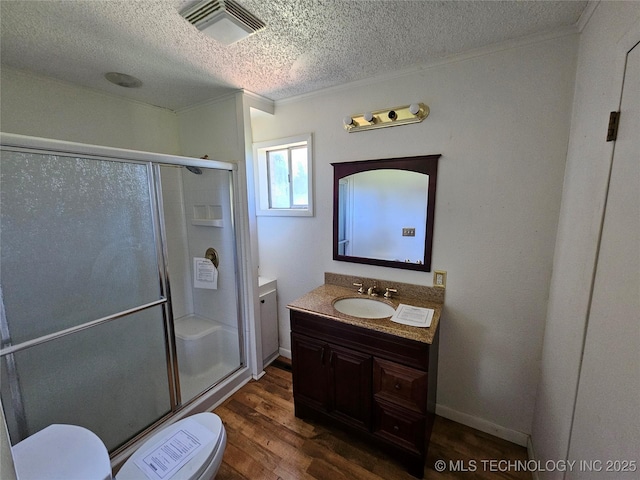 2700 N Witte St, Poteau, OK 74953 - full bathroom with a textured ceiling, toilet, vanity, wood finished floors, and a shower stall