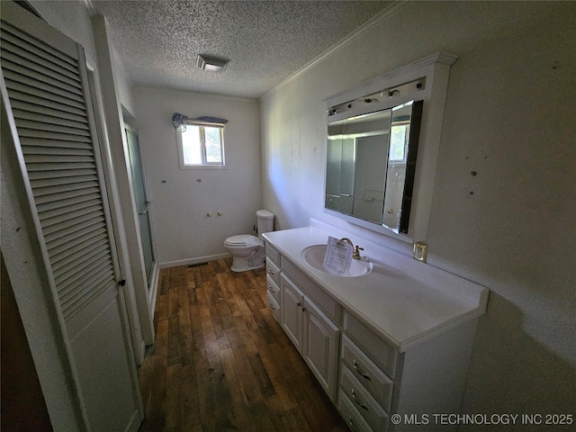 2700 N Witte St, Poteau, OK 74953 - bathroom with a stall shower, vanity, toilet, a textured ceiling, and wood-type flooring