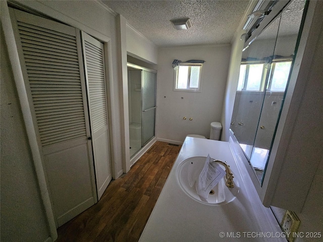 2700 N Witte St, Poteau, OK 74953 - full bathroom with a shower stall, wood finished floors, a textured ceiling, vanity, and a closet