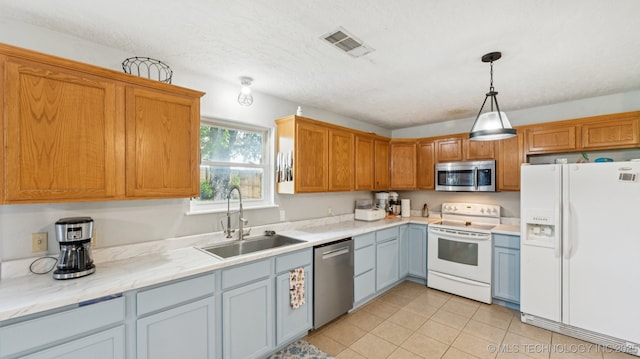 4964 SE Brookline Dr, Bartlesville, OK 74006 - kitchen featuring stainless steel appliances, light tile patterned floors, and hanging light fixtures