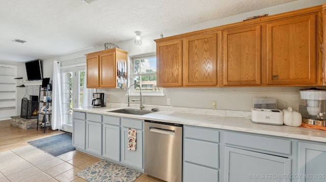 4964 SE Brookline Dr, Bartlesville, OK 74006 - kitchen featuring stainless steel dishwasher, a lit fireplace, and light tile patterned floors