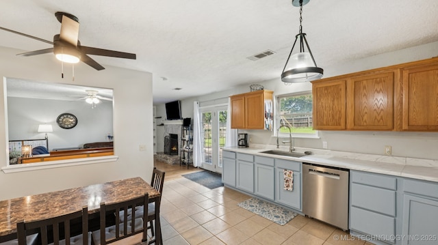 4964 SE Brookline Dr, Bartlesville, OK 74006 - kitchen featuring stainless steel dishwasher, a ceiling fan, light tile patterned floors, light countertops, and hanging light fixtures