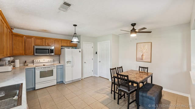 4964 SE Brookline Dr, Bartlesville, OK 74006 - kitchen with white appliances, light countertops, a ceiling fan, light tile patterned flooring, and hanging light fixtures