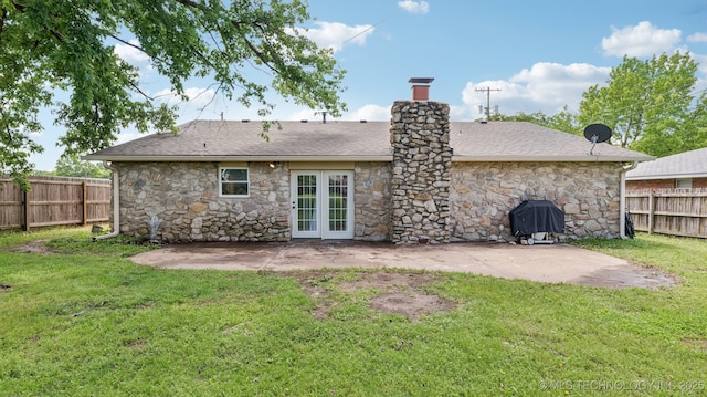 4964 SE Brookline Dr, Bartlesville, OK 74006 - back of property with stone siding, a fenced backyard, a patio area, french doors, and a chimney