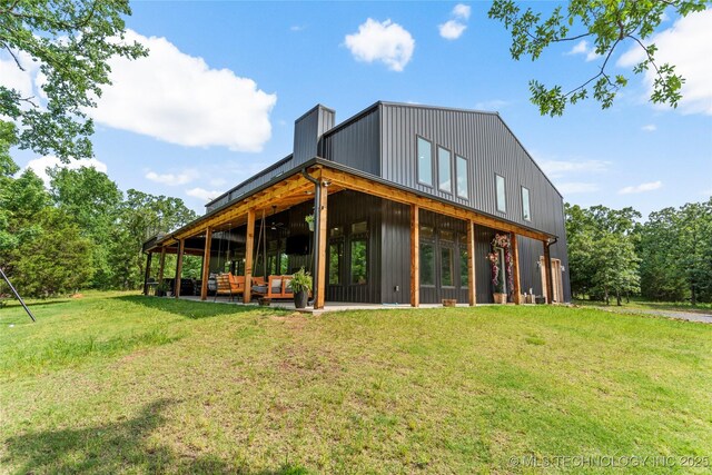 8562 Adams Creek Rd, Beggs, OK 74421 - rear view of house with an outdoor living space, a yard, and a chimney